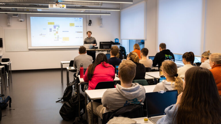 Tjenestedesigner Eivind Reibo jentoft presenterer om designdrevet innovasjon i et klasserom for en gruppe ergoterpistudenter ved Universitet i Tromsø.